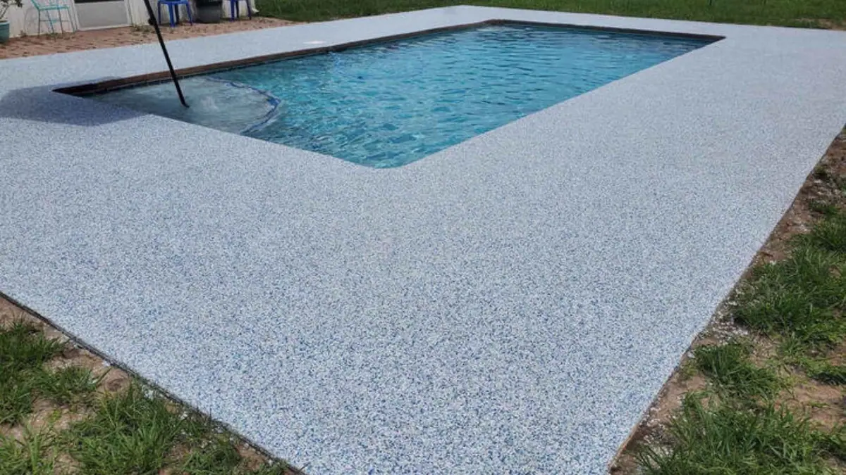 Coated pool deck around a backyard swimming pool