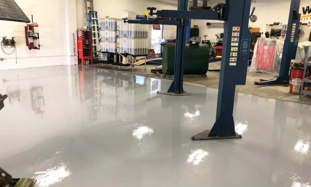Auto repair shop with vehicle lifts and a light gray coated floor